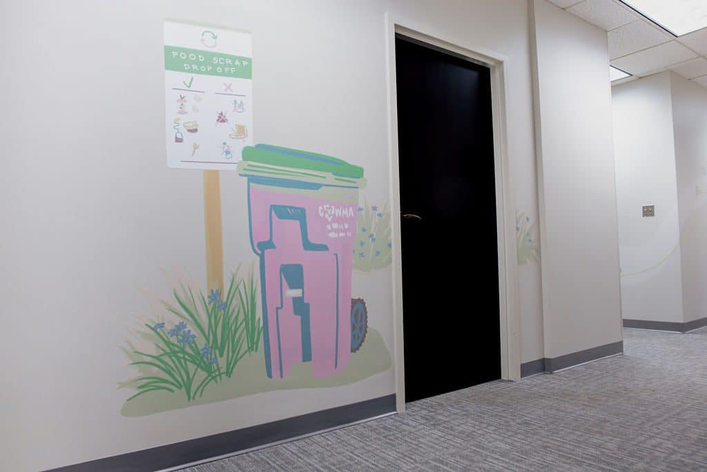 A mural of a recycling cart among flowers on a CVWMA office wall